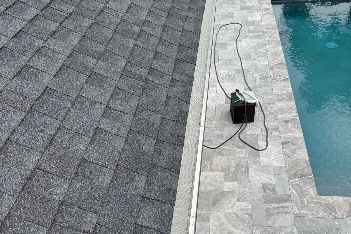 Micromesh gutter guard installed along a roofline beside a pool